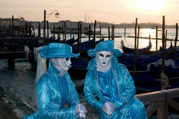 Die Masken sind bei den Gondeln an der Molo schweigend ins Gespr&auml;ch vertieft.